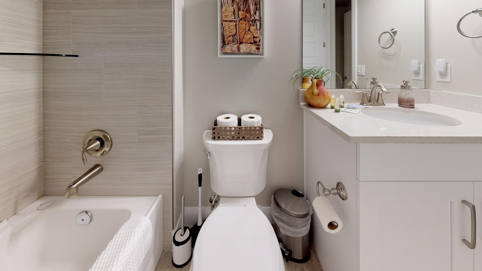 A modern bathroom with a bathtub, toilet, and sink.