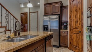 A kitchen with granite countertops, stainless steel appliances, wooden cabinets, and a stainless steel refrigerator. - Beyond The Green 4 Bedroom Townhouse by RedAwning (Washington)