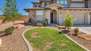 A two-story house with a stone facade, a garage, and a landscaped front yard with a curved pathway.