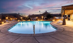 A swimming pool with lounge chairs and a stone wall. - Canyon Oasis 4 Bedroom Apts by RedAwning (Washington)