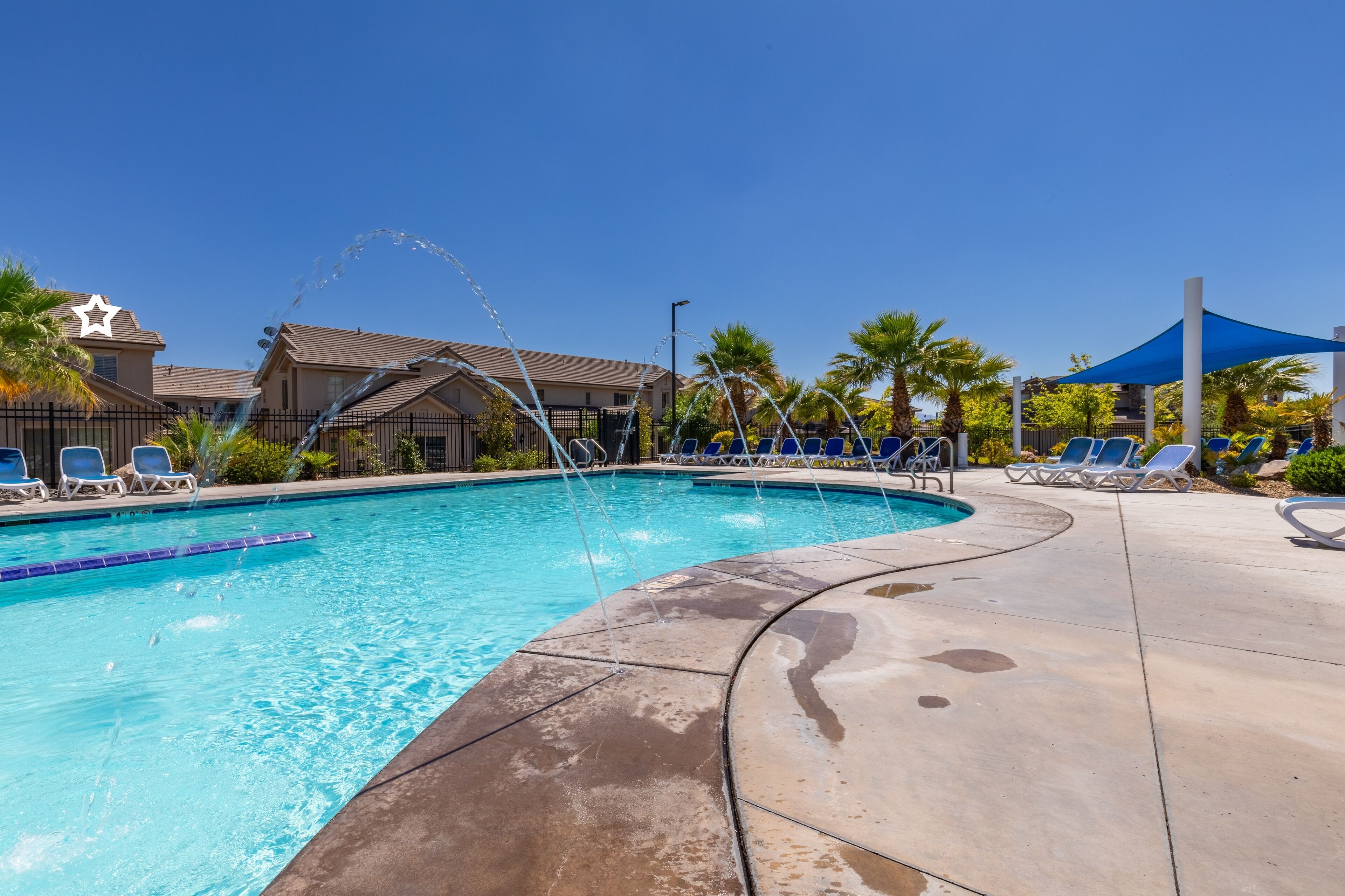 A swimming pool with lounge chairs and a water feature.