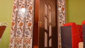 A room with a patterned door, a red couch, and a ceiling with a textured design. - Tollview Classic Hotel (Ruiru)