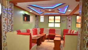 A room with a sofa set, a table, and a television. - Tollview Classic Hotel (Ruiru)