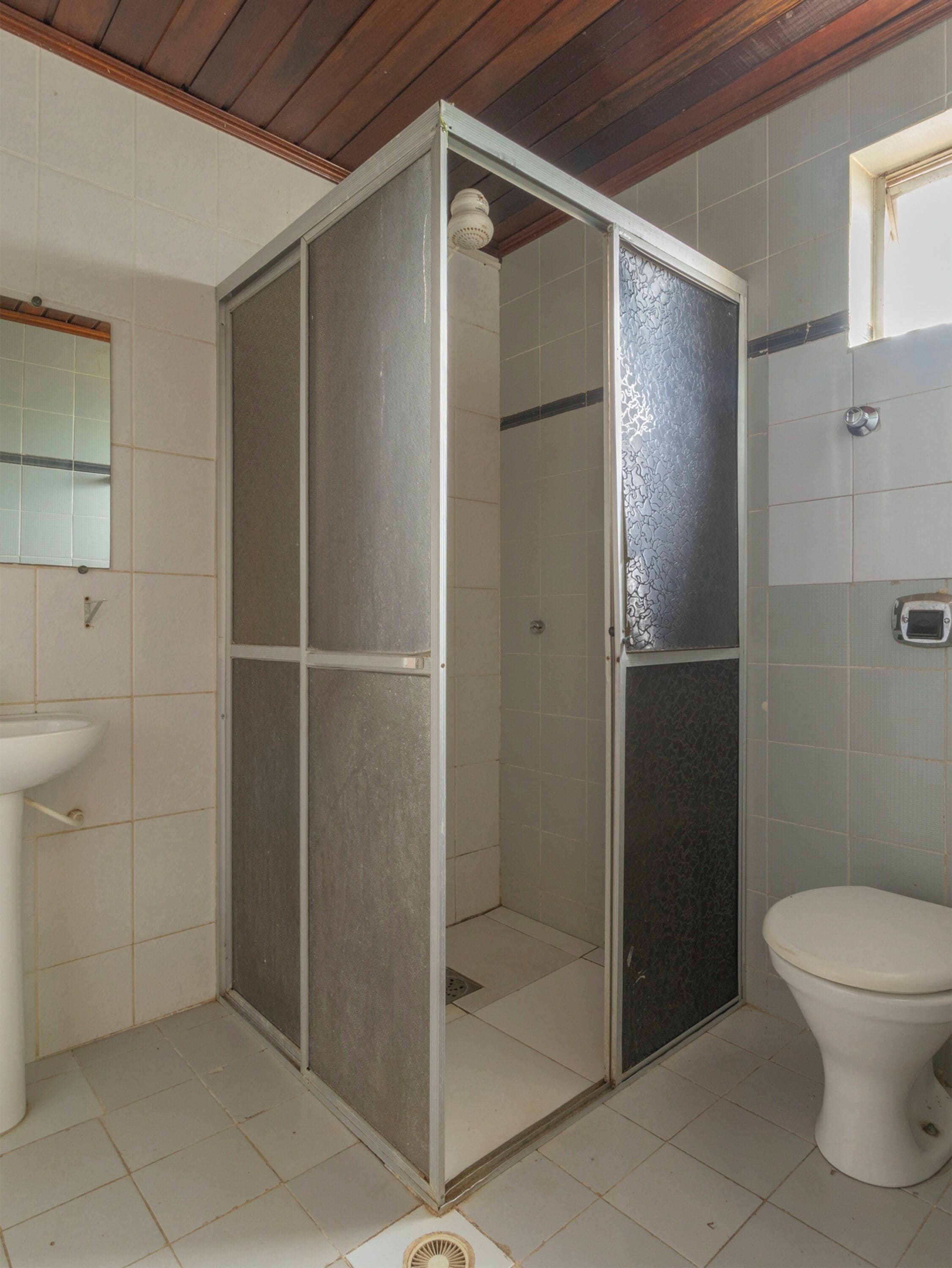 Un baño con cabina de ducha, inodoro y lavamanos.