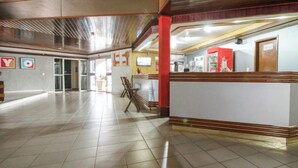 A spacious lobby with a tiled floor, a reception desk, and a television screen. - OYO New Anápolis Hotel, Imperatriz (Imperatriz)