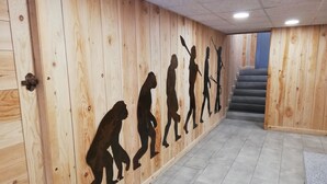 Käytävä, jonka seinät on verhoiltu puupaneeleilla, ja toisessa seinässä on esitetty ihmisen evoluution aikajana.