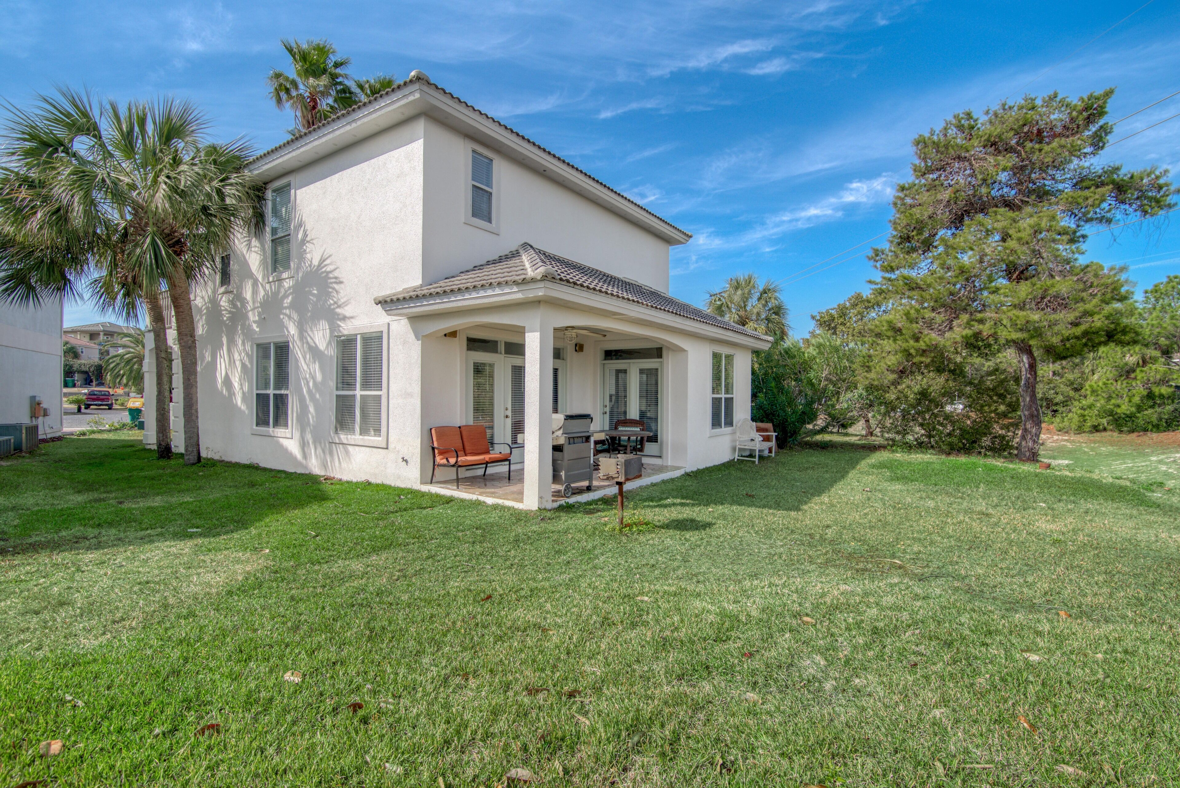 A two-story house with a covered porch and a lawn.