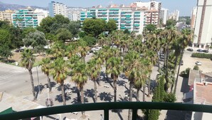 Vista de un paisaje urbano con edificios altos, palmeras y cielo despejado.