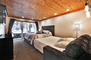 Une chambre avec un grand lit, un canapé, une télévision et une lampe.