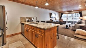 A kitchen with wooden cabinets, a granite countertop, and a built-in island. - Top of Main Street - TMI with Parking (Park City)