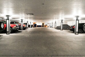 A parking garage with multiple cars parked and a trash bin in the center. - Top of Main Street - TMI with Parking (Park City)