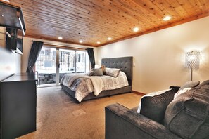 Une chambre à coucher avec un lit, un canapé, une télévision et une lampe.