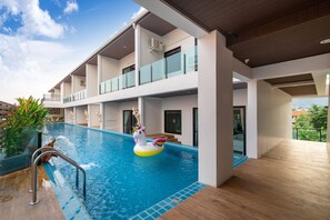 A modern hotel with a rooftop pool, a unicorn float, and a view of the city. - The Thames Pool Access Resort SHA+ (Chalong)