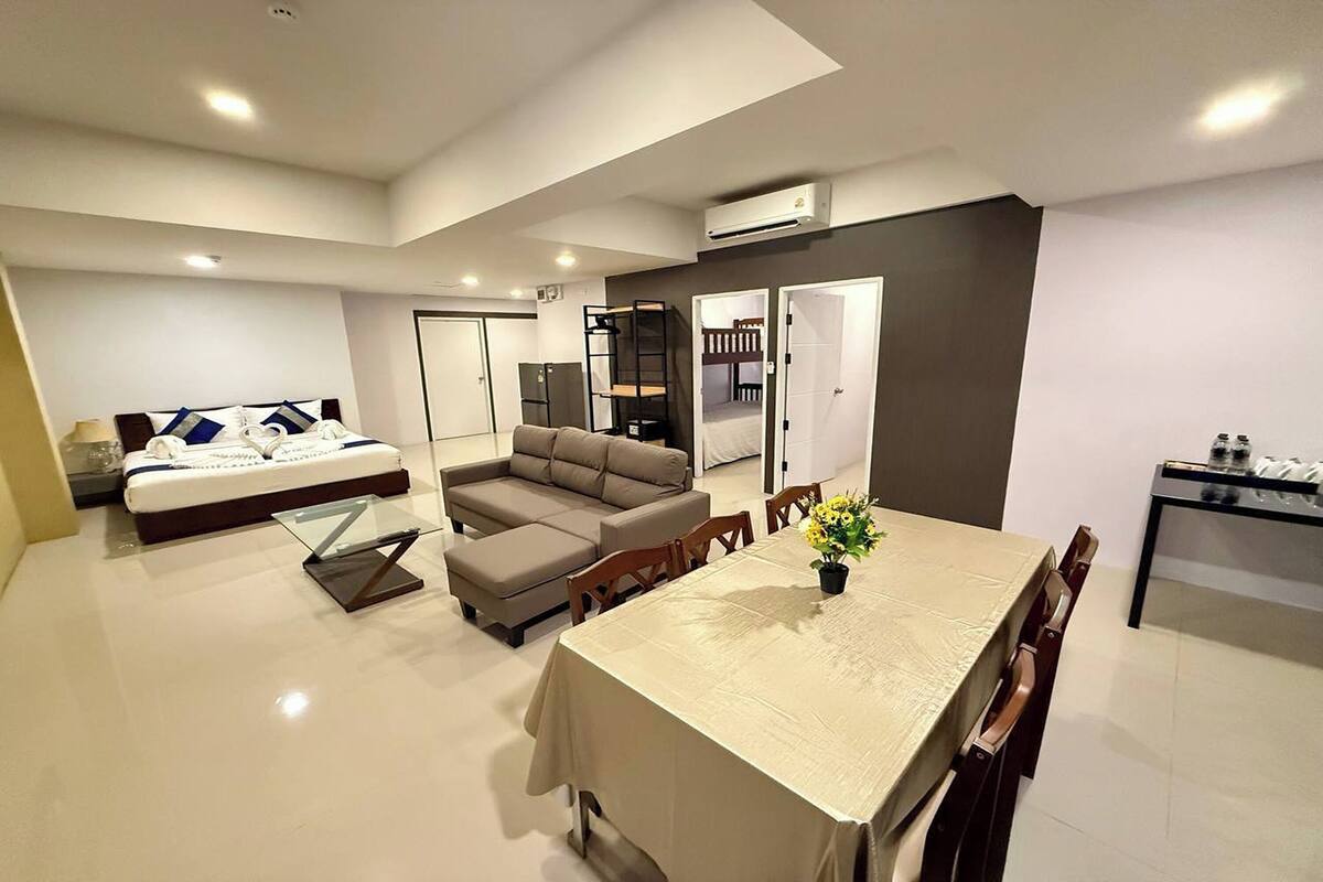Una sala de estar moderna con sofá, una mesa de comedor y una zona de cocina.