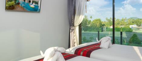 A hotel room with a large window, a bed with white linens and a red and black striped blanket, and a view of a pool and greenery outside.