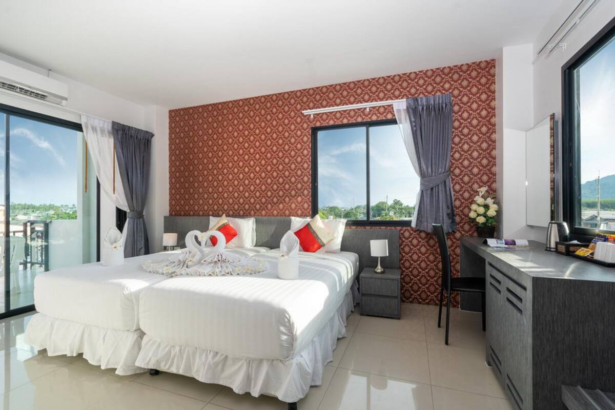 Una habitación de hotel moderna con una cama grande, un escritorio y un balcón con vistas.