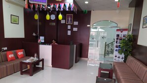 A reception area with a reception desk, a sofa, a coffee table, and a plant.