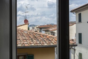 A view of terracotta-tiled rooftops and a satellite dish, indicating a residential area with traditional architecture. - Eolo Apartment (Florence)