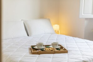 Relax in comfort with a neatly made bed, complete with a cozy tray of treats.