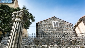 Un edificio de piedra con techo inclinado y una ventana con contraventanas.