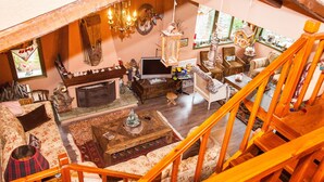 Un salon confortable avec une cheminée, un téléviseur et un escalier menant à l’étage supérieur.