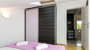 Een moderne slaapkamer met een bed, een schuifdeur en uitzicht op een balkon.