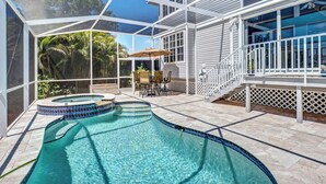 A covered swimming pool with a hot tub, patio furniture, and a view of the surrounding greenery. - Minutes to Vanderbilt beach-1/2 mile !! Heated Pool/Spa 2650 sq ft (Naples)