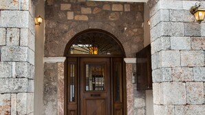 A stone entrance with a wooden door and steps leading up to it. - Apollon Stone Villa in Delphi (Delphi)
