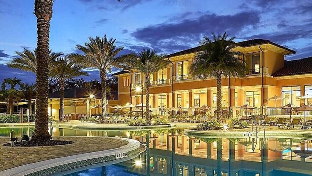A hotel with a swimming pool, palm trees, and a well-lit outdoor area. - #2700 Resort 2Master Priv Spa Disney Epic Universe (Kissimmee)