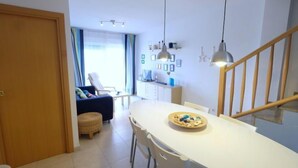 Una cucina moderna con tavolo, sedie e lampade a sospensione.