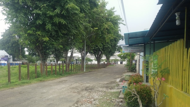 A paved road leading to a building with a signboard.