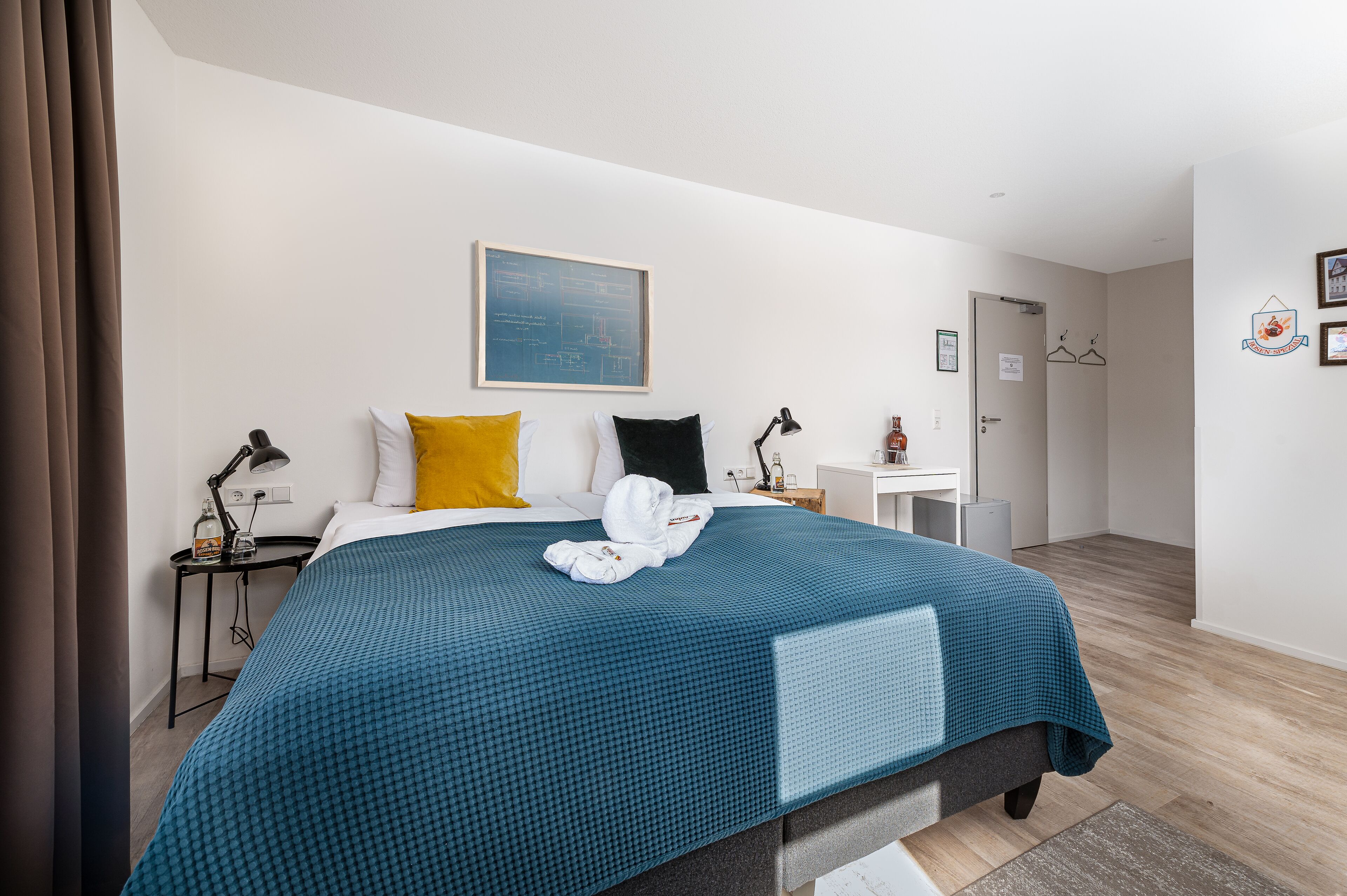 Een moderne hotelkamer met een groot bed, een bureau en een klein witte tafeltje.