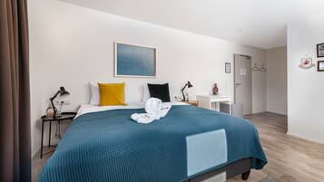 Ein modernes Hotelzimmer mit einem großen Bett, einem Schreibtisch und einem kleinen weißen Tisch.