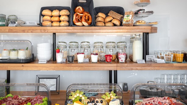 Een buffet met diverse gerechten, waaronder brood, pretzels en kaas.