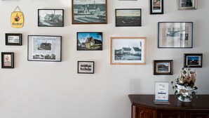 Een muur met verschillende ingelijste foto's en een bord met vakantie-attributen.