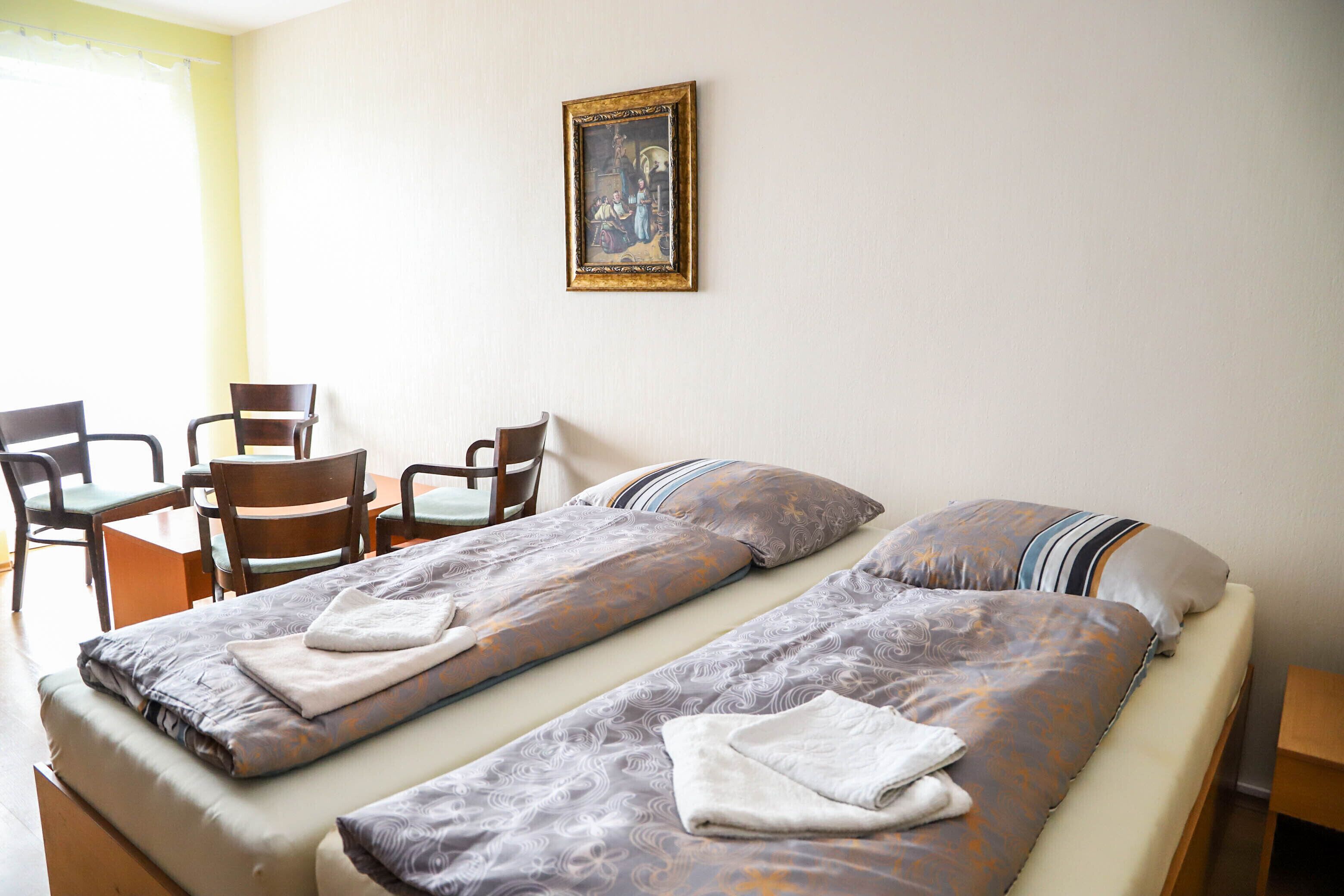 Una habitación de hotel con dos camas, una mesa de comedor y sillas.