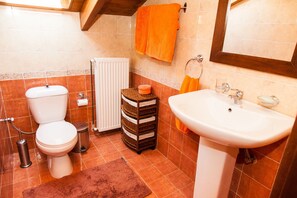 Une salle de bain équipée de toilettes, d’un lavabo et d’un porte-serviettes.