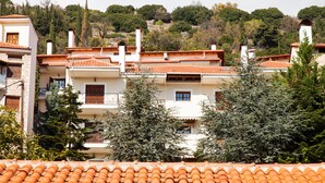 Un quartier résidentiel caractérisé par des toits recouverts de tuiles en terre cuite, des murs blancs et de nombreux arbres.
