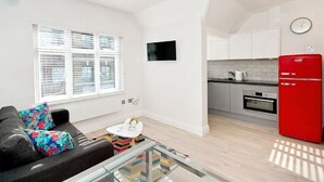 Een modern appartement met een woonkamer, keuken en eetgedeelte.