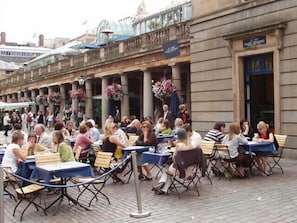 Outdoor dining area with tables and chairs set on a paved surface.
