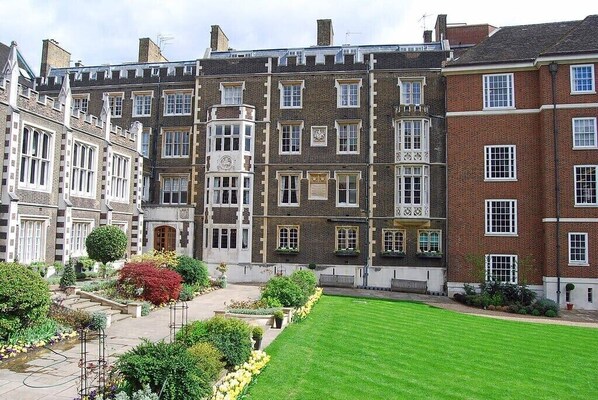 Traditional building with a symmetrical facade, featuring a mix of brick and stone construction, and a well-manicured garden.
