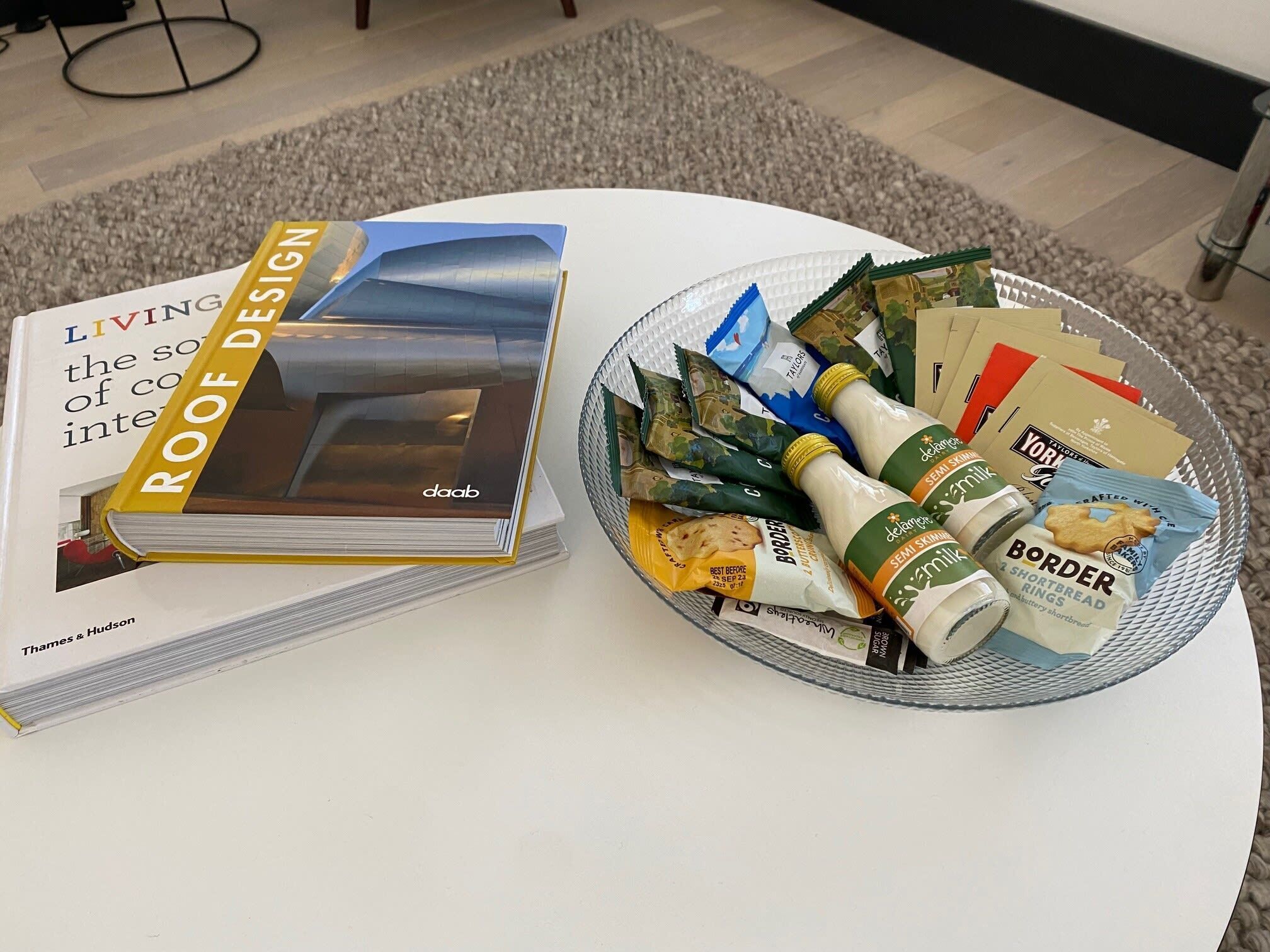 A book titled 'Living the Soul of Co...' and a plate with food items including a bottle and packets.