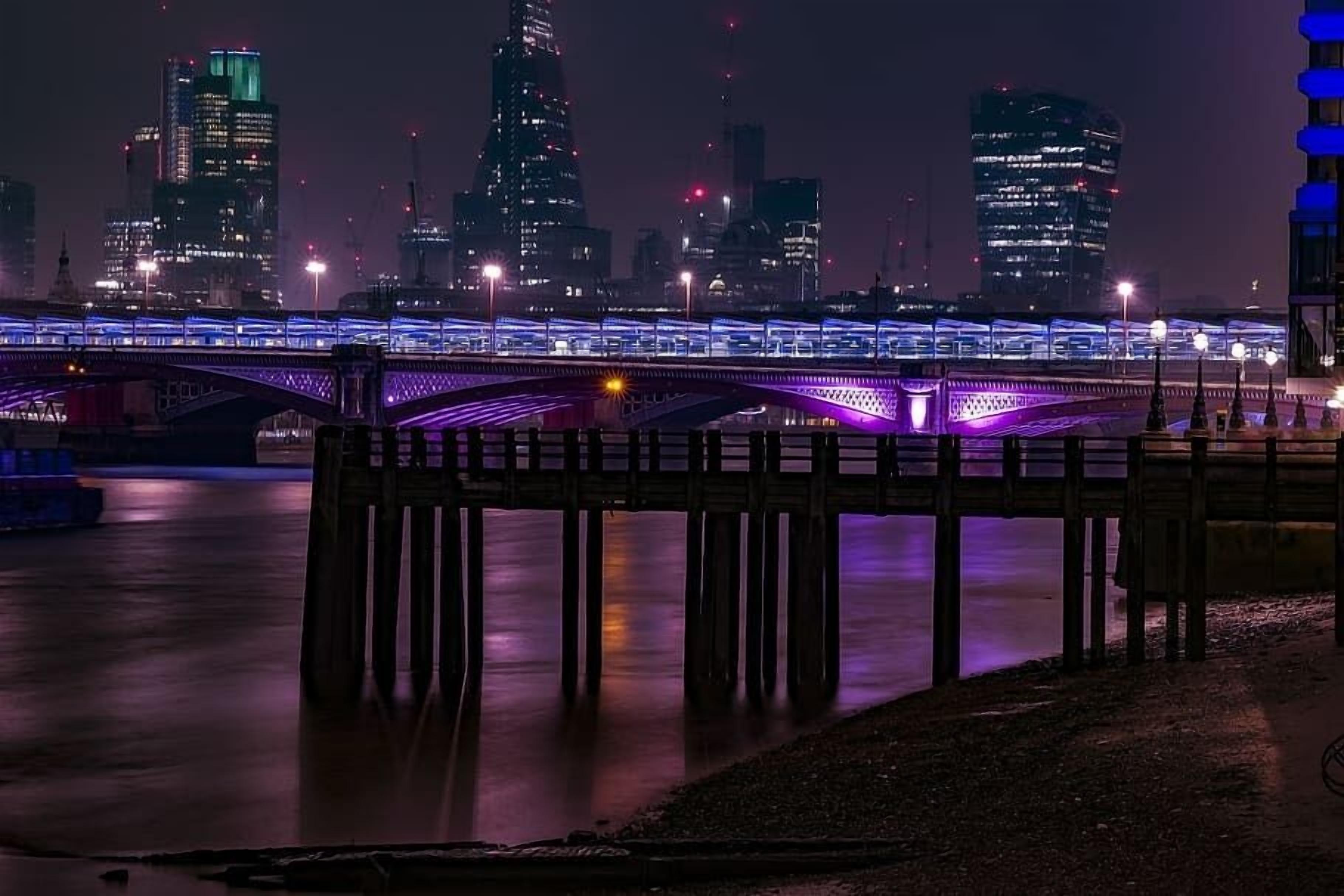 A nighttime cityscape with illuminated bridges and buildings.