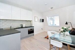 Enjoy meals in the kitchen with oven and dining area with glass-top table.
