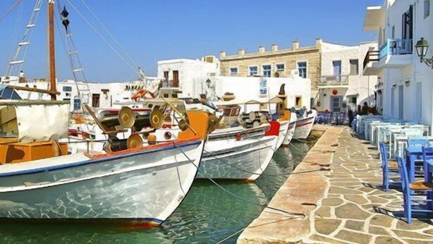 A narrow street lined with boats docked along the water, with white buildings and stone pavement. - An apartment that sleeps 4 guests  in 1 bedroom (Paros)