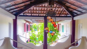A staircase with a ceiling that has a tiled pattern and a hanging decorative light fixture. - Rede Andrade Porto Center Hotel (Porto Seguro)