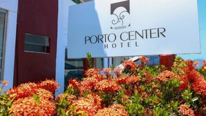 A sign for Porto Center Hotel with a logo and the hotel's name. - Rede Andrade Porto Center Hotel (Porto Seguro)