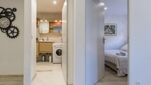 A modern bedroom with a bed, a small bedside table, and a nightstand.