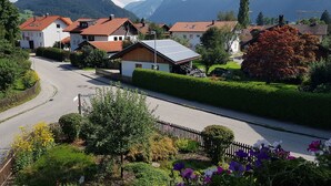 Una calle residencial con casas, una vía y montañas al fondo.