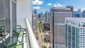 A balcony with a view of a cityscape, including tall buildings and a clear sky.